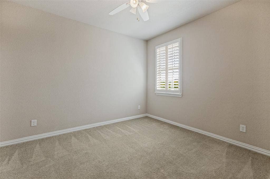 Second upstairs bedroom with ceiling fan and plantation shutters