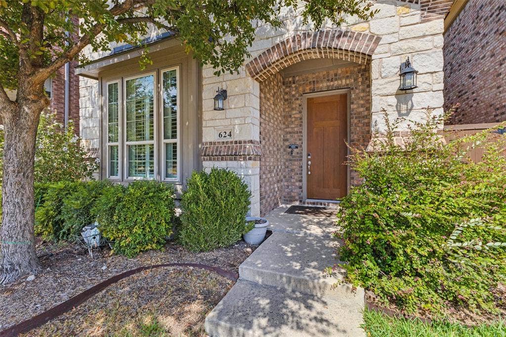 Stone and brick exterior featuring a covered arched entry