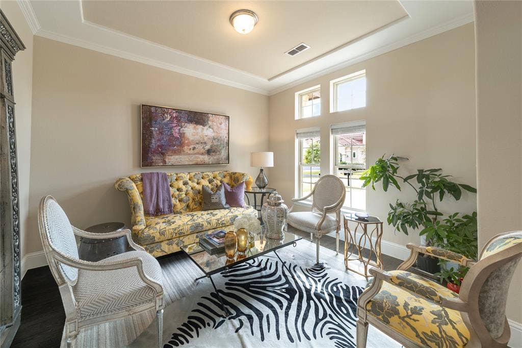 13018 Seattle Slew Street, Frisco, TX 75035 Tray ceiling with crown molding, light-toned walls, wood-finish flooring, multiple windows with blinds, and a built-in recessed light fixture