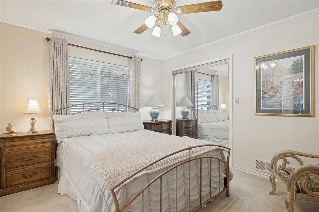 Window with blinds, ceiling fan with light fixture, carpeted flooring, and mirrored closet doors