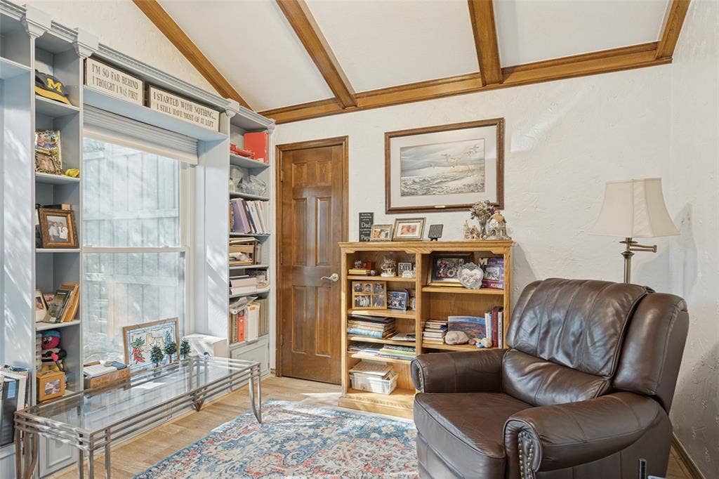 Vaulted ceiling with exposed wood beams, wood-finish flooring