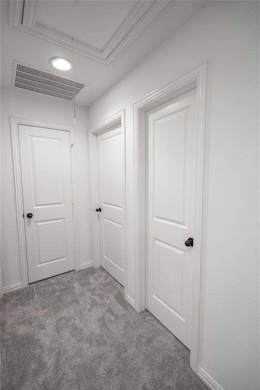 White interior doors with black hardware, plush gray carpet flooring, recessed ceiling lighting, and a framed attic access panel