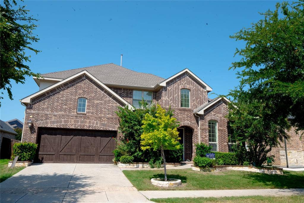 Brick exterior with stone accents, arched windows, and a multi-gabled roofline