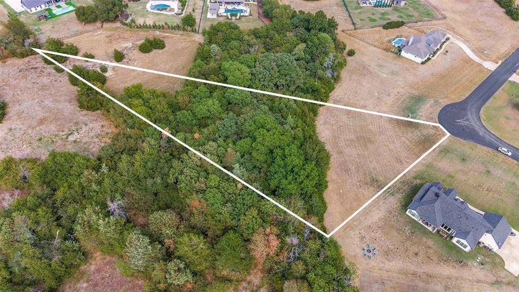Aerial shows the 2.02 acres with large front grassy area, open area in back, wooded area in middle. Also shows large circle in street where Twilight Dr. bends.