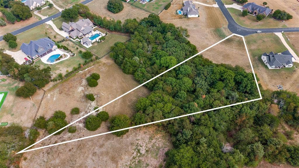 Aerial with a different drone elevation and angle showing more open space in the back of the lot, and the beautiful native trees!