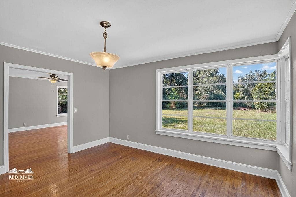 3749 Bobbitt Drive, Shreveport, LA 71107 View looks into the living room near the kitchen door with a bank of windows overlooking the backyard