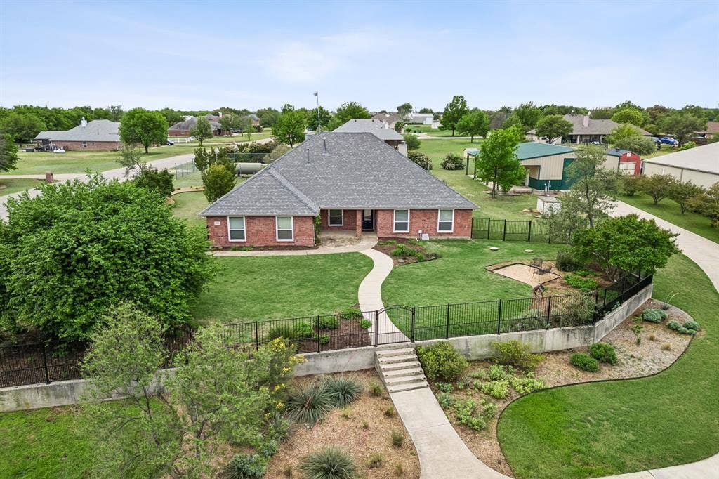 Elevated Homesite With Manicured Landscaping And Wrought Iron Fence