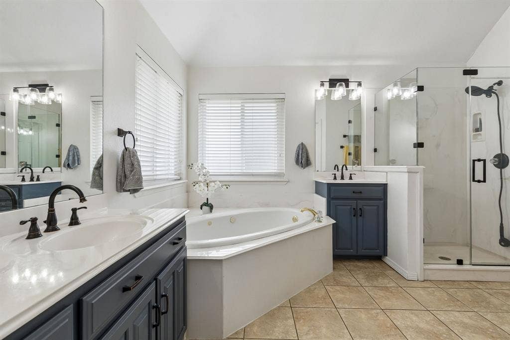 Primary Bath Featuring Jetted Soaking Tub, Dual Vanities, And Walk-In Closet