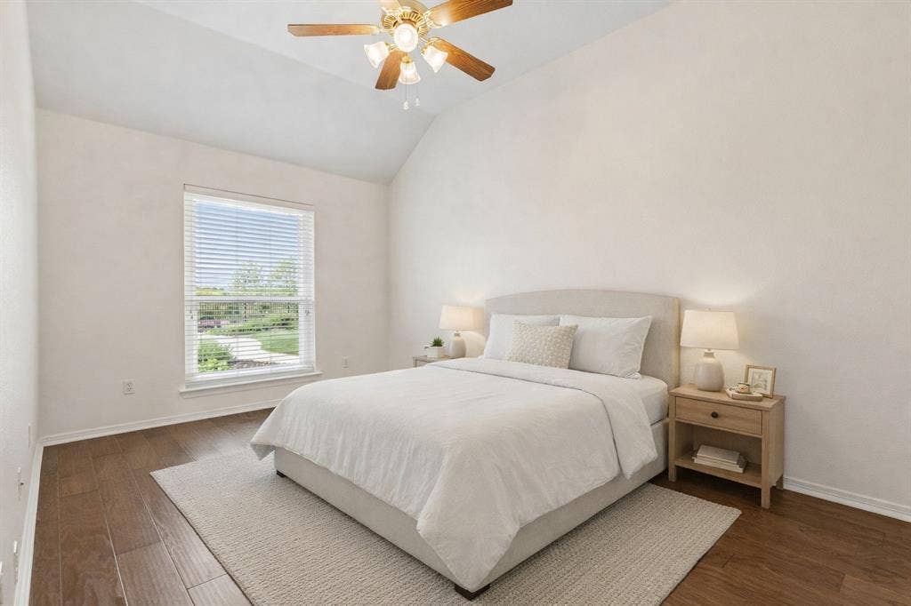 Comfortable Bedroom With Wood Floors And Ceiling Fan