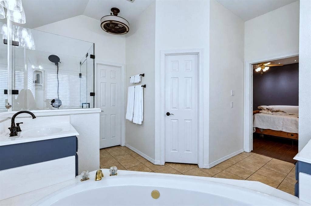 Luxurious Primary Bath With Glass Shower, Jetted Tub, And Large Walk-In Closet