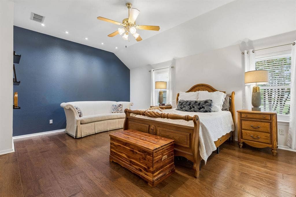 Primary Suite Featuring Wood Flooring, Accent Paint, And Ceiling Fan