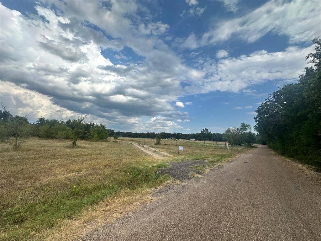 12496 County Road 2148, Kemp, TX 75143 Expansive open land featuring a gravel road, natural vegetation, and mature trees