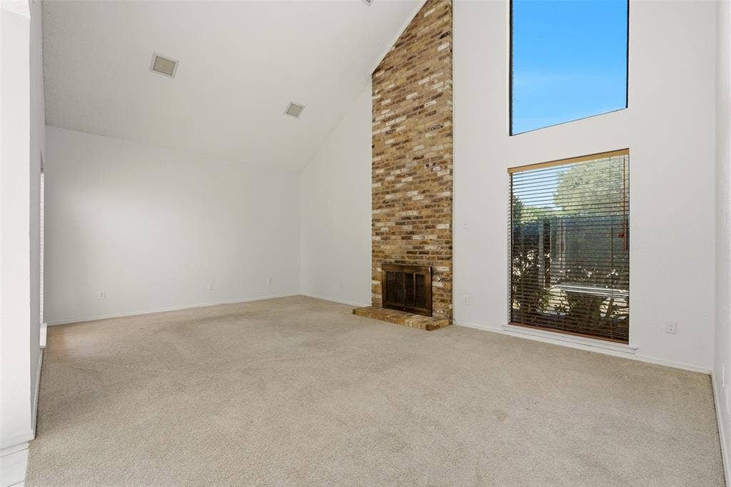 1512 Woodcreek Drive, Richardson, TX 75082 Vaulted ceiling, brick fireplace, and tall windows
