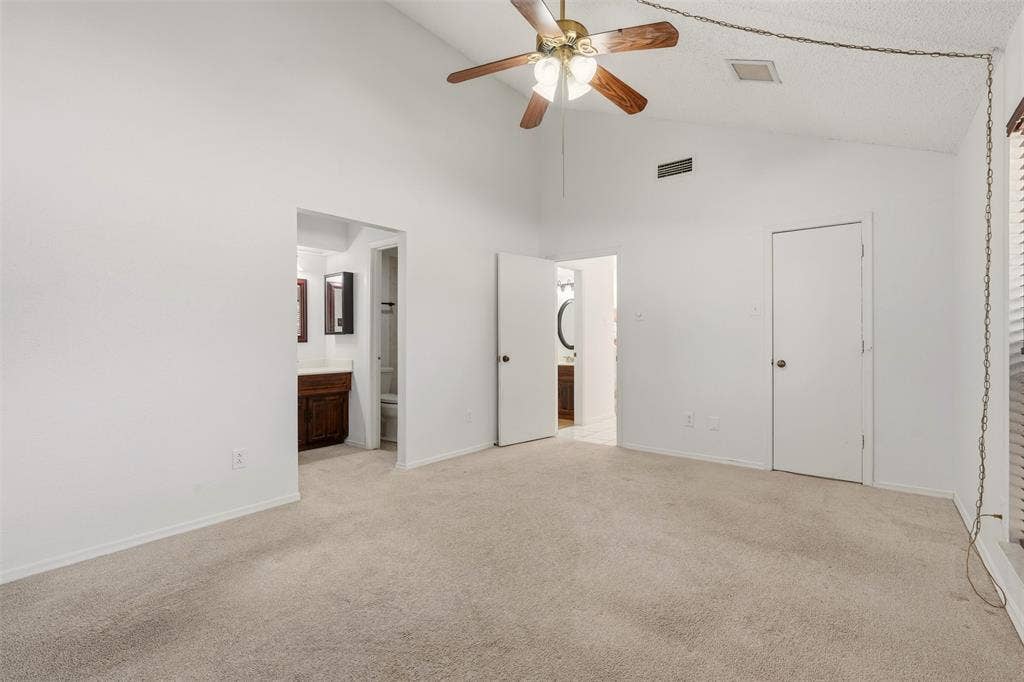 1512 Woodcreek Drive, Richardson, TX 75082 Vaulted ceiling with a ceiling fan, carpeted flooring, and white interior doors