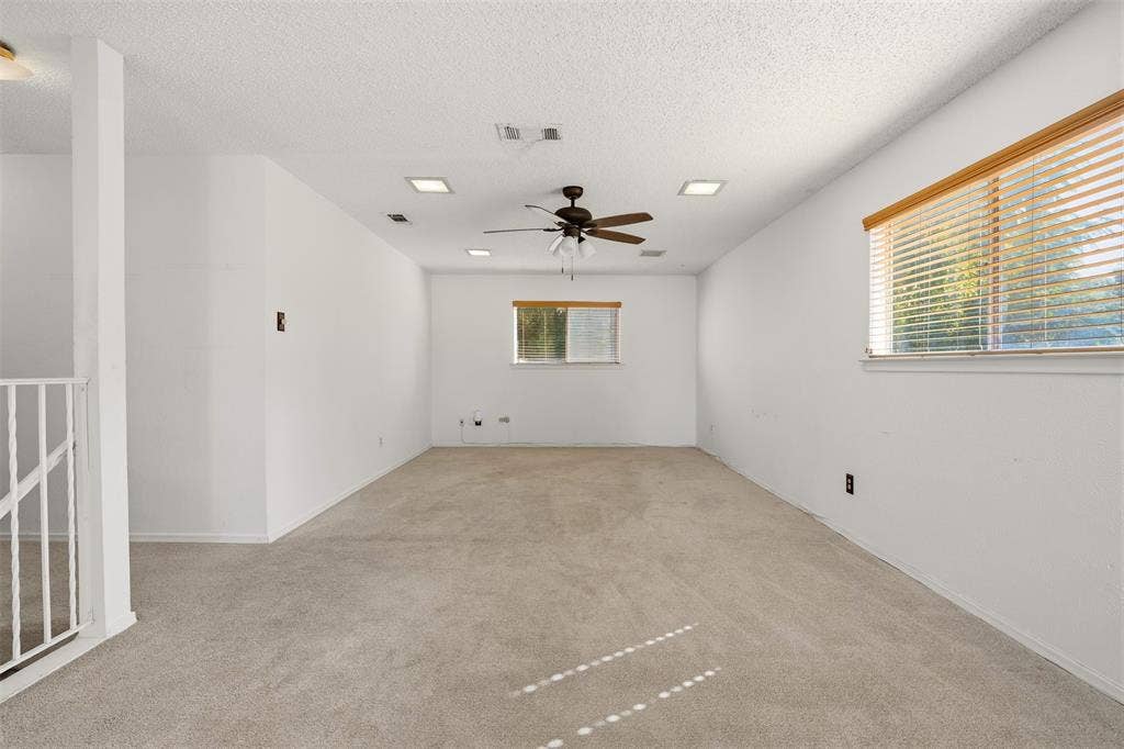 1512 Woodcreek Drive, Richardson, TX 75082 Spacious room featuring neutral carpeting, a ceiling fan, recessed lighting, and multiple windows with blinds