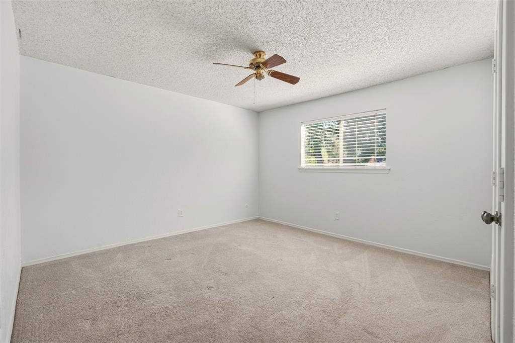 1512 Woodcreek Drive, Richardson, TX 75082 Recessed window with horizontal blinds, ceiling fan with integrated lighting, and neutral carpeting
