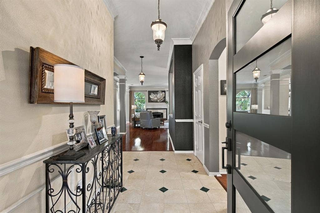 3106 Morning Dove, McKinney, TX 75072 Entryway featuring tiled flooring with accent inlays, crown molding, and a solid-core door with glass panels