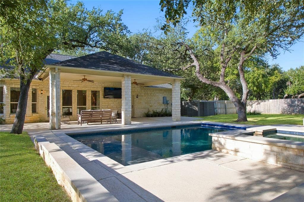 11408 Somerville Drive, Temple, TX 76502 Outdoor pool with adjacent spa, covered patio with stone columns, and stone exterior