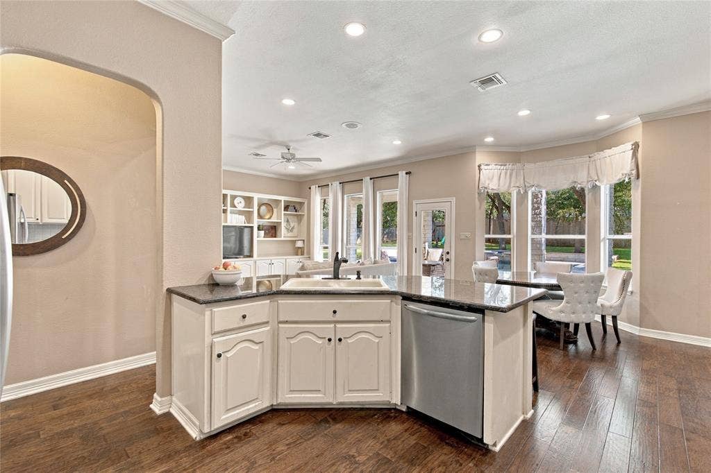 11408 Somerville Drive, Temple, TX 76502 Kitchen island with an undermount sink, a stainless steel dishwasher, and a dark stone countertop