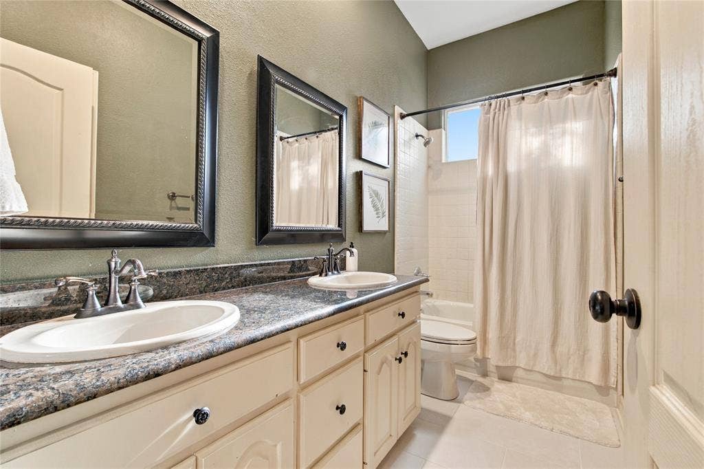 11408 Somerville Drive, Temple, TX 76502 Dual vanity with undermount sinks, speckled countertop, and light-toned cabinetry