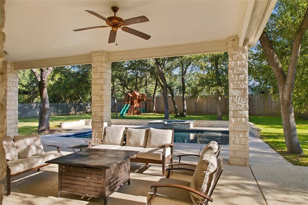 11408 Somerville Drive, Temple, TX 76502 Covered patio with stone columns, ceiling fan, concrete flooring, and a swimming pool
