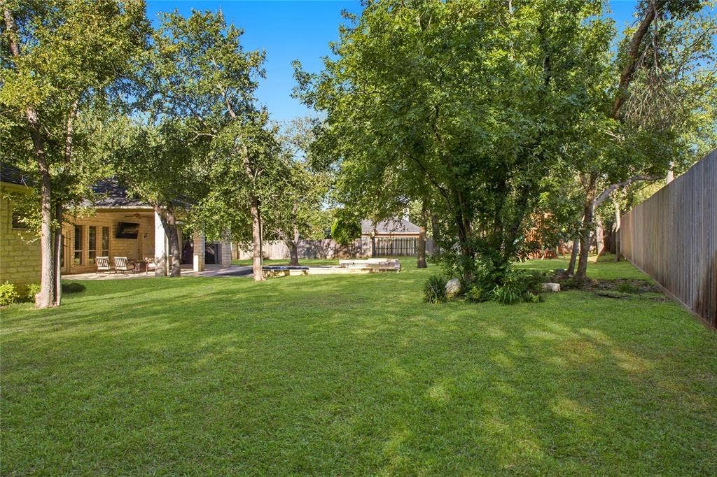 11408 Somerville Drive, Temple, TX 76502 Expansive backyard featuring a manicured lawn, mature trees, and a privacy fence