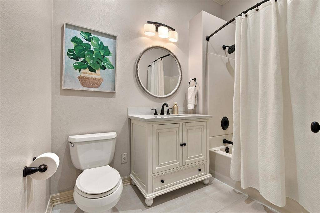 11408 Somerville Drive, Temple, TX 76502 White vanity with a single basin sink, matte black faucet, and round mirror