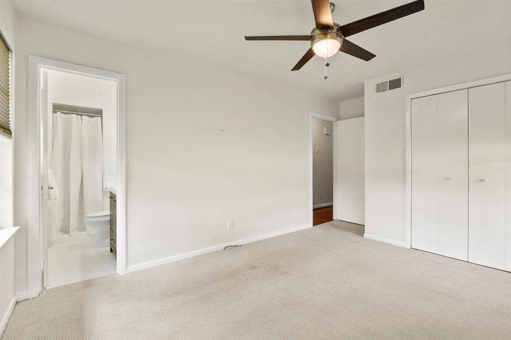Carpeted room with a ceiling fan, window with blinds, and built-in closet with bi-fold doors