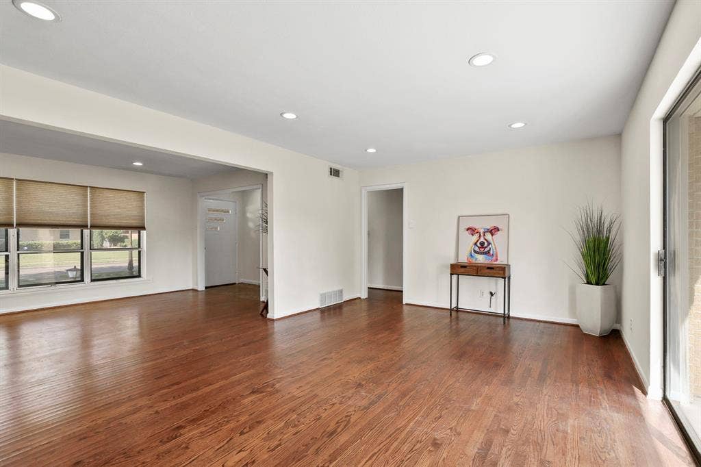 Hardwood flooring throughout, recessed lighting, and multiple windows with blinds