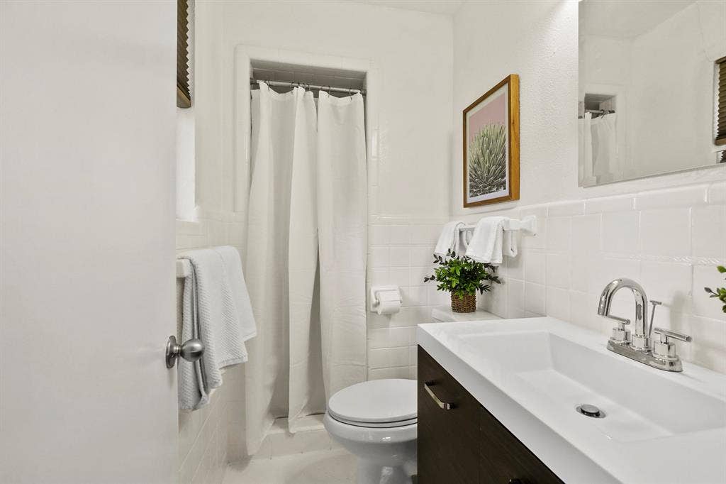 Integrated vanity with a single basin, chrome faucet, and dark wood-finish cabinetry