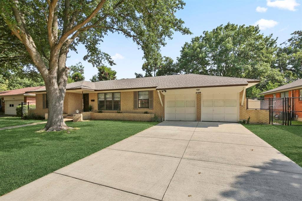 Brick exterior with a gabled roof, a two-car garage, and a concrete driveway