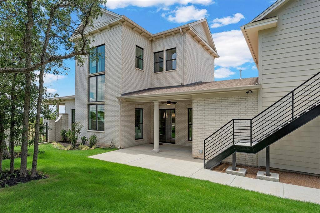 20 N Ritchie Road, Woodway, TX 76712 White brick exterior with a covered patio, black framed windows, and a metal outdoor staircase