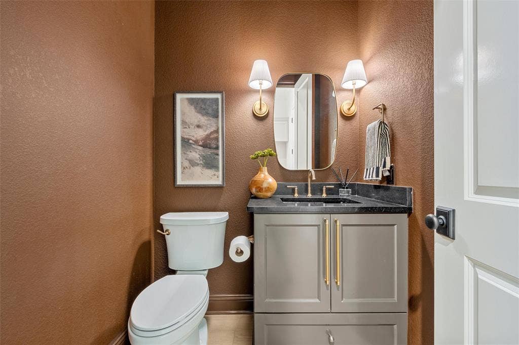 20 N Ritchie Road, Woodway, TX 76712 Gray vanity with golden hardware, black countertop, and gold-finish faucet