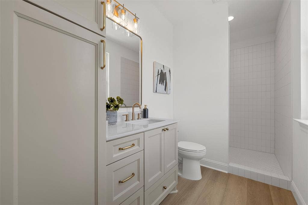 20 N Ritchie Road, Woodway, TX 76712 White shaker vanity with gold-finish hardware, rectangular undermount sink, and a white countertop