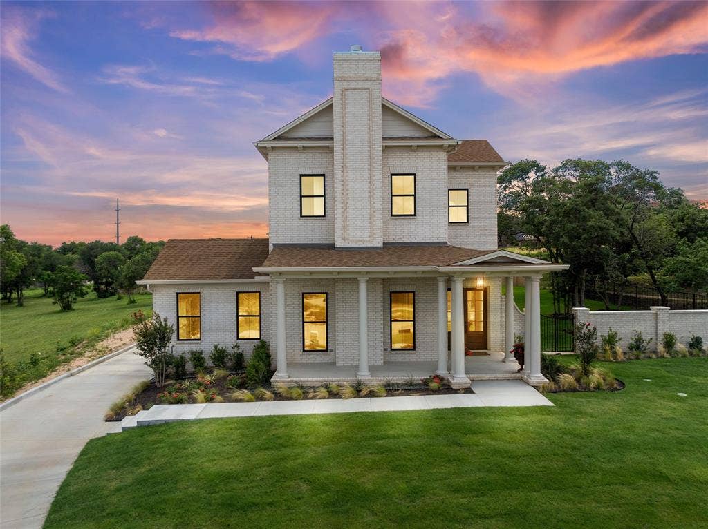 20 N Ritchie Road, Woodway, TX 76712 Two-story residence featuring a brick exterior, prominent chimney, covered front porch with columns, and a concrete driveway