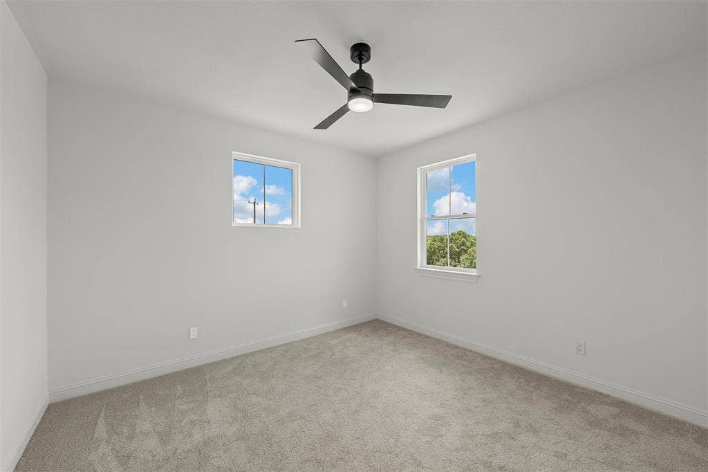 20 N Ritchie Road, Woodway, TX 76712 Neutral wall paint, carpeted flooring, two windows, and a ceiling fan with integrated lighting