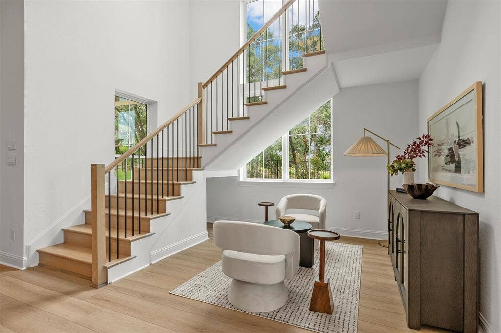 20 N Ritchie Road, Woodway, TX 76712 Light wood-finish flooring, two-story ceilings, a staircase with wood treads and balusters, and expansive windows