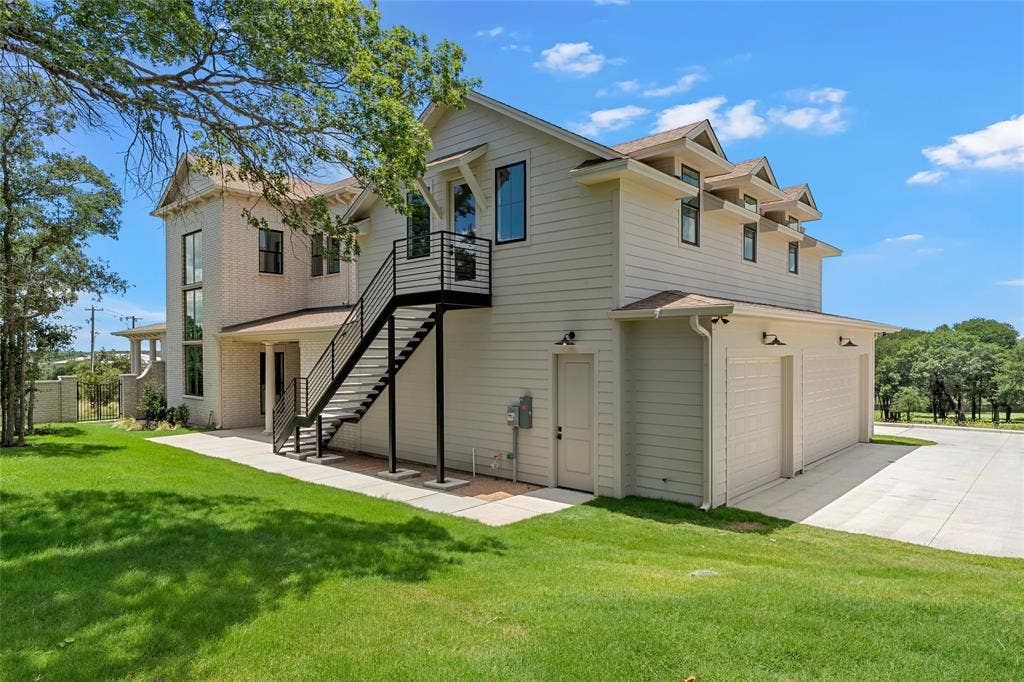 20 N Ritchie Road, Woodway, TX 76712 Contemporary exterior featuring a two-car garage, dormer windows, and an external staircase with metal railings