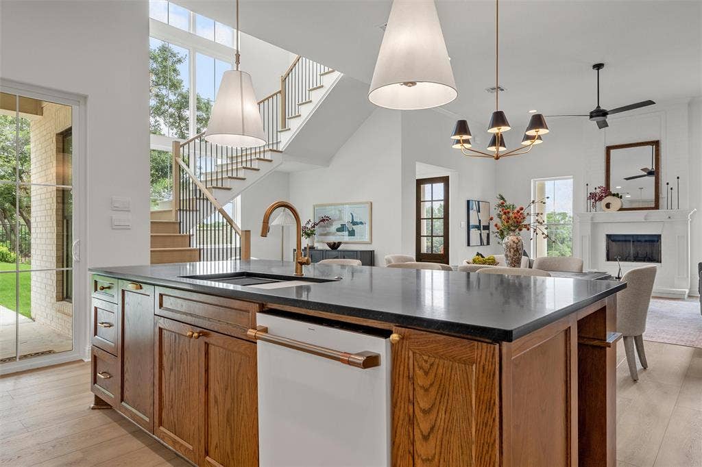 20 N Ritchie Road, Woodway, TX 76712 Kitchen island with dark countertop, integrated sink, and bronze-finish faucet