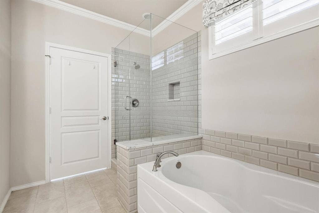1641 Overwood Drive, Frisco, TX 75036 Walk in glass shower enclosure, recessed shower niche, subway tile accents, soaker tub, and tile flooring