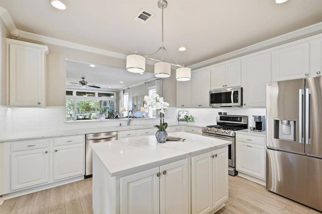 1641 Overwood Drive, Frisco, TX 75036 Kitchen featuring white cabinetry, stainless steel appliances, a center island with a quartz countertop, wood-finish flooring and extra cabinets