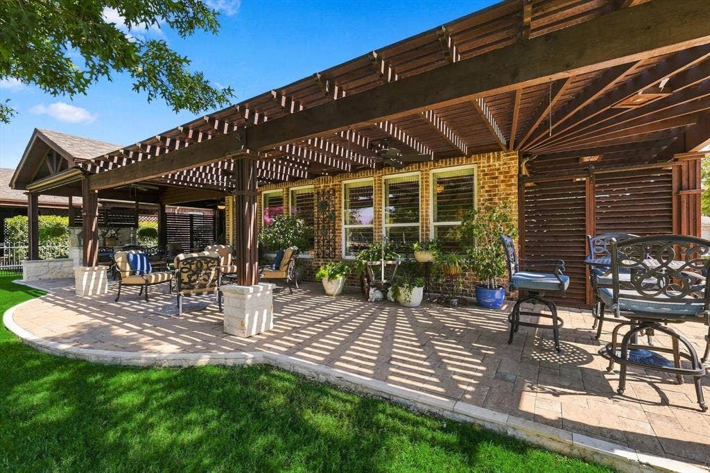 1641 Overwood Drive, Frisco, TX 75036 Expansive paver patio with a wood pergola, brick exterior, and multiple windows