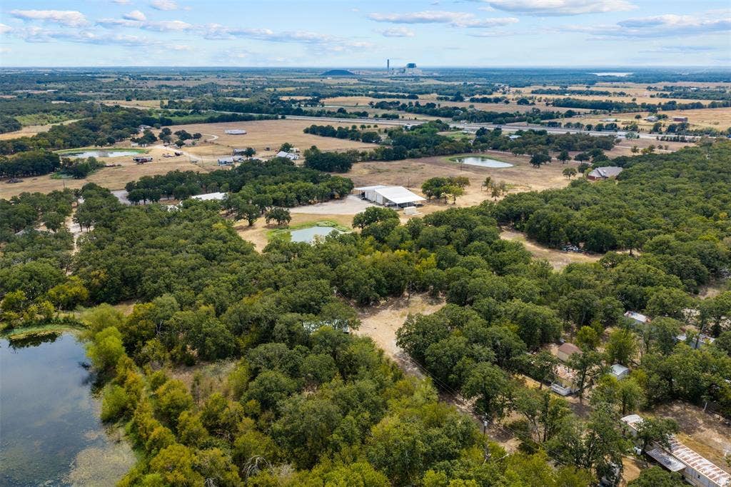 172 M Burton Street, Riesel, TX 76682 Expansive acreage featuring mature trees, a natural pond, and distant open fields