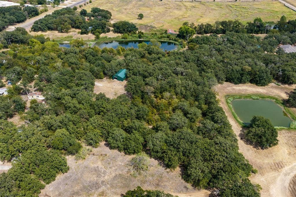 172 M Burton Street, Riesel, TX 76682 Expansive wooded acreage featuring three ponds and a green-roofed outbuilding