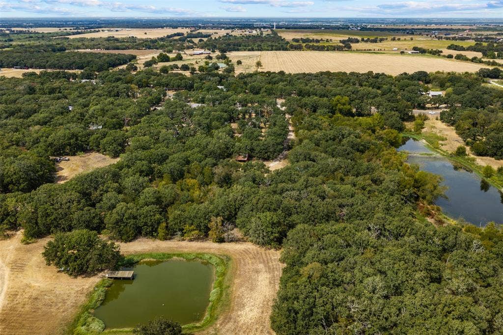 172 M Burton Street, Riesel, TX 76682 Expansive acreage featuring abundant mature trees, two distinct ponds, and open fields
