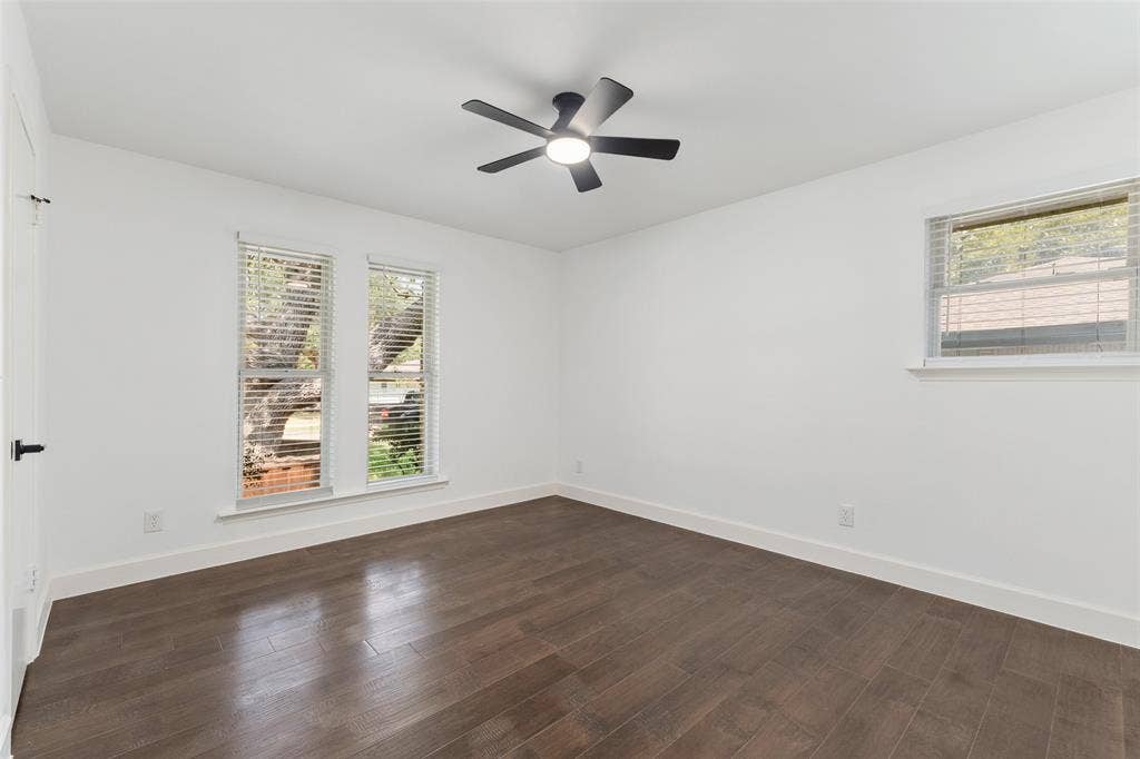 1612 Northcrest Drive, Plano, TX 75075 Smooth white walls, dark wood-finish flooring, and a modern ceiling fan with integrated lighting