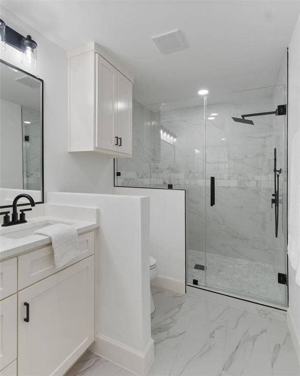 1612 Northcrest Drive, Plano, TX 75075 Bathroom featuring a glass-enclosed shower with black fixtures, white vanity with integrated sink, white upper cabinetry, and large format tile flooring