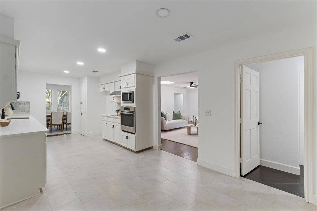 1612 Northcrest Drive, Plano, TX 75075 White cabinetry with stainless steel appliances, recessed lighting, and light-toned flooring
