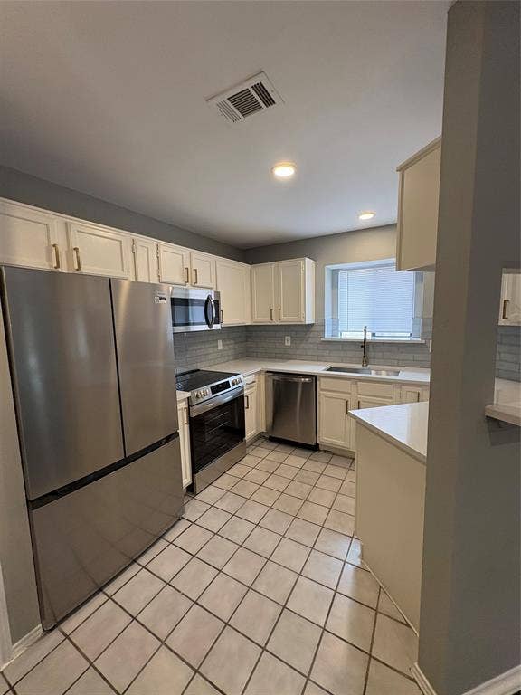 1120 Old Barn Lane, Mesquite, TX 75149 Stainless steel appliances, white cabinetry, tile flooring, light-toned countertops, and a subway tile backsplash