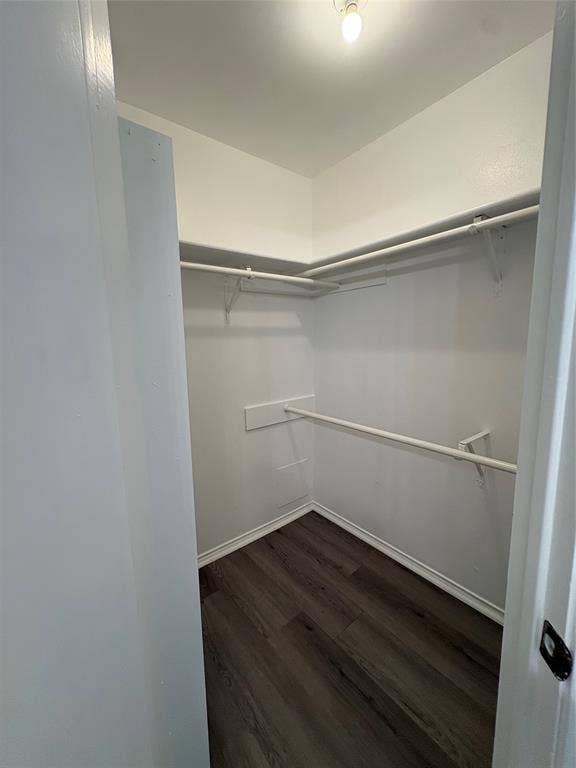 1120 Old Barn Lane, Mesquite, TX 75149 Walk-in closet featuring wood-finish flooring, white walls, and built-in shelving with hanging rods